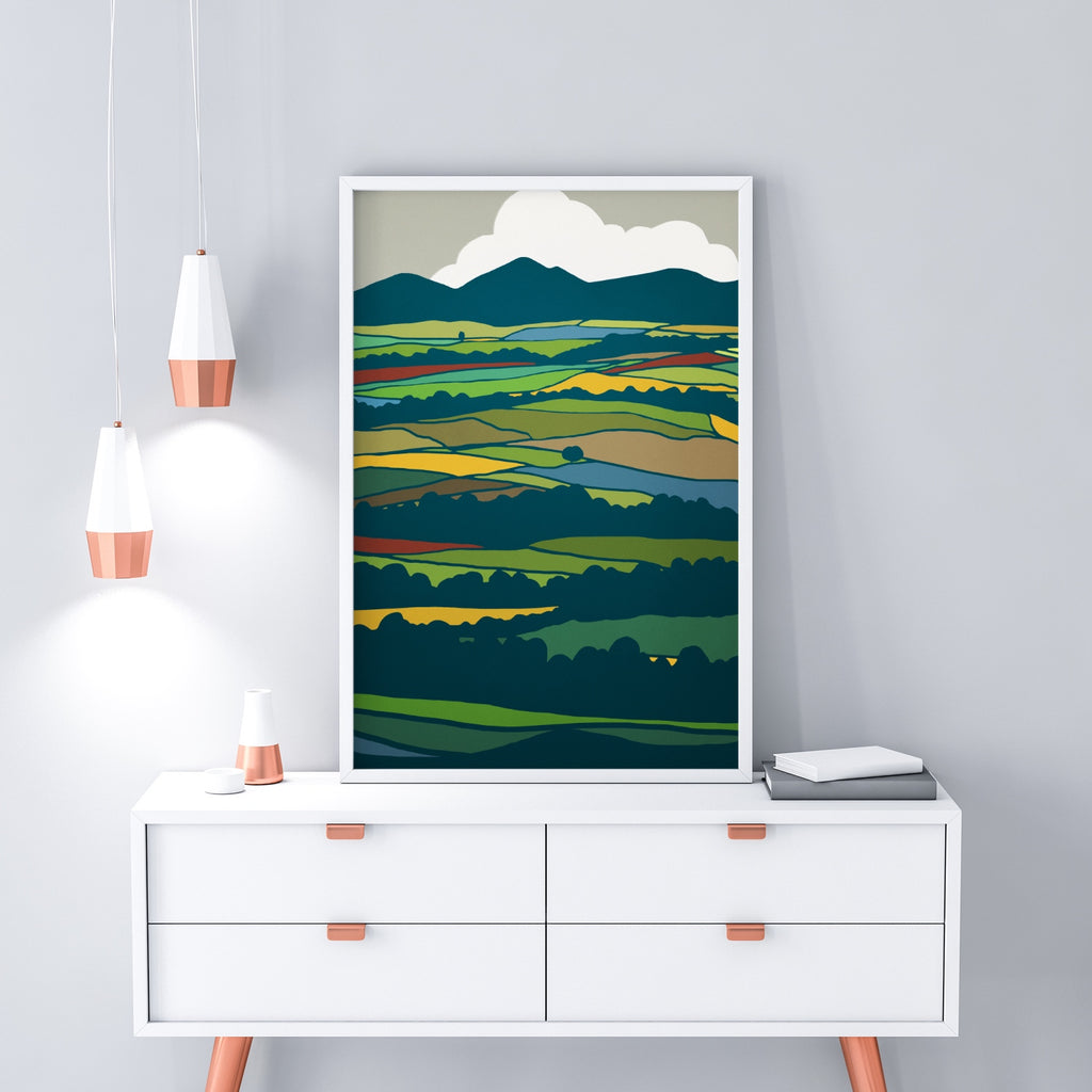 A country landscape artwork featuring a colorful patchwork of fields.